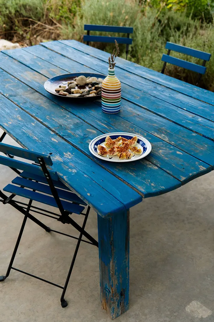 Lunch laid out on the blue outdoor table with blue folding chairs
