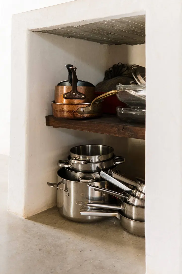 Copper and steel pans stored in a deep plastered niche
