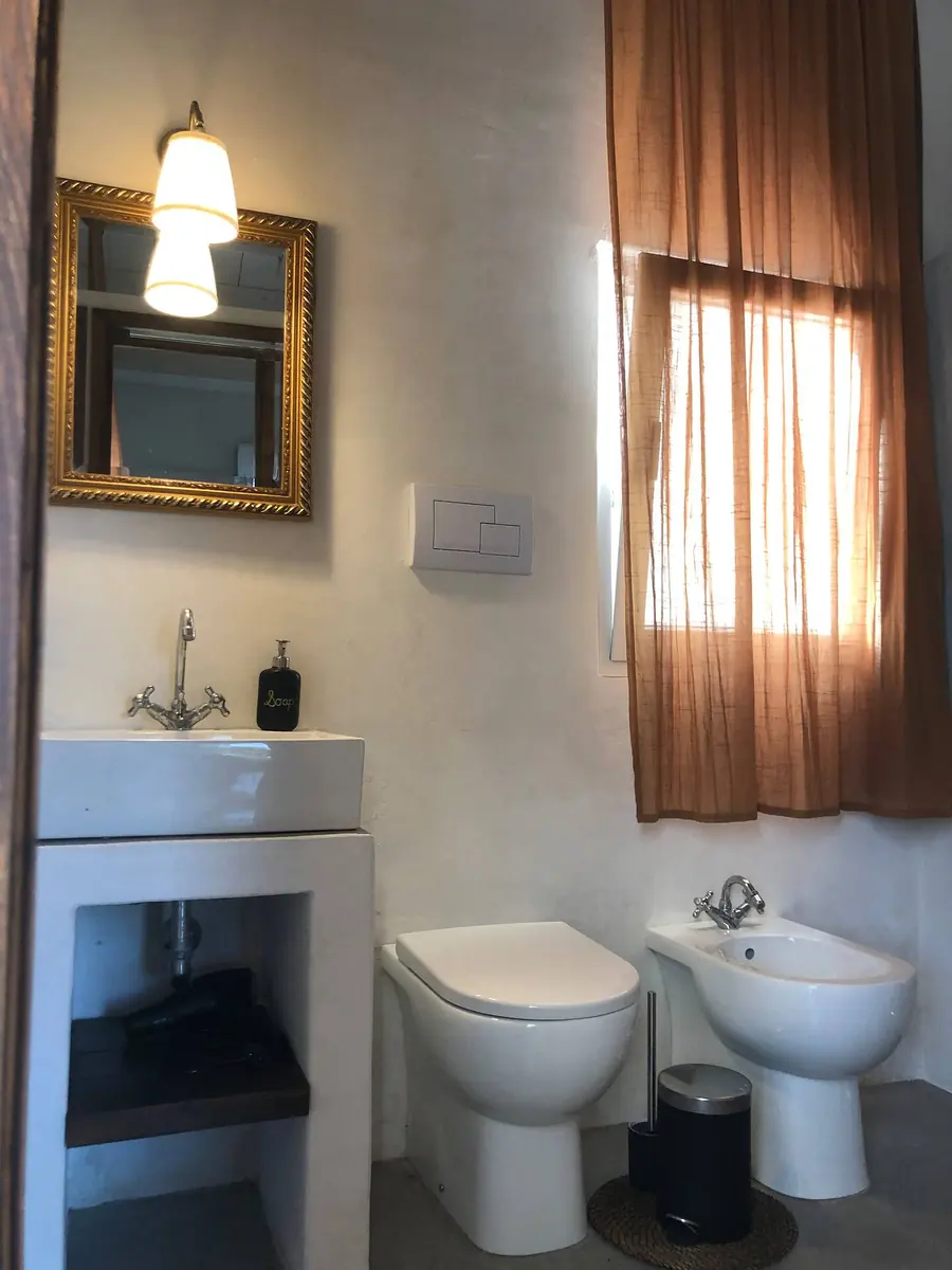 The bathroom for Room 1, with a basin, mirror, toilet and bidet